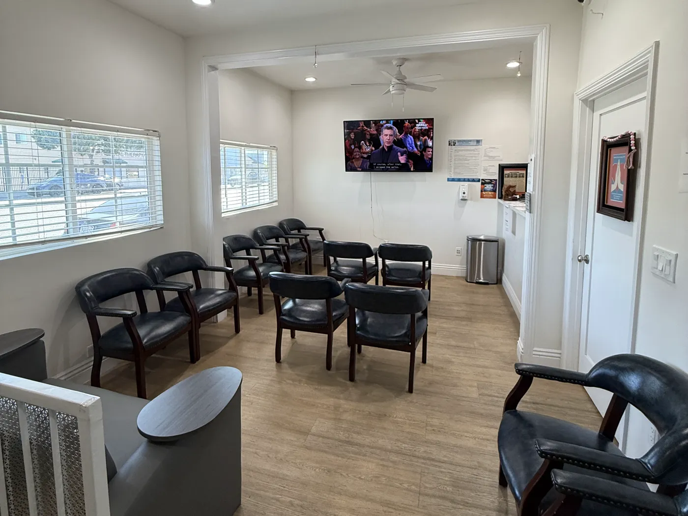 Waiting room seating with a television and natural light from the front windows